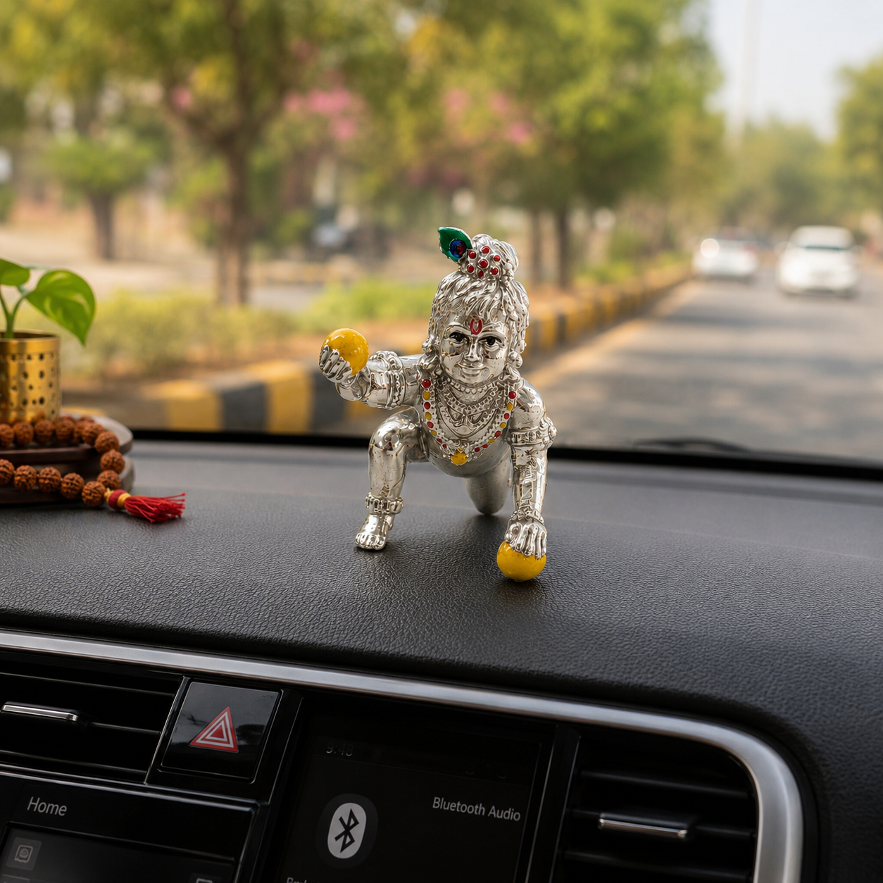 Small Laddu Gopal Murti placed on an Indian car dashboard for a devotional and peaceful touch.