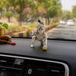 Small Laddu Gopal Murti placed on an Indian car dashboard for a devotional and peaceful touch.