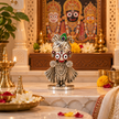 Jagannath Ji brass idol with silver finish displayed on a car dashboard