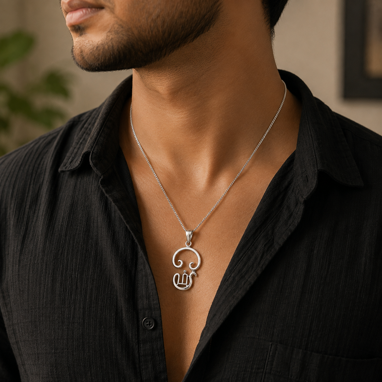Tamil Om pendant in brass silver finish worn by woman in white embroidered kurta showing pendant close to chest