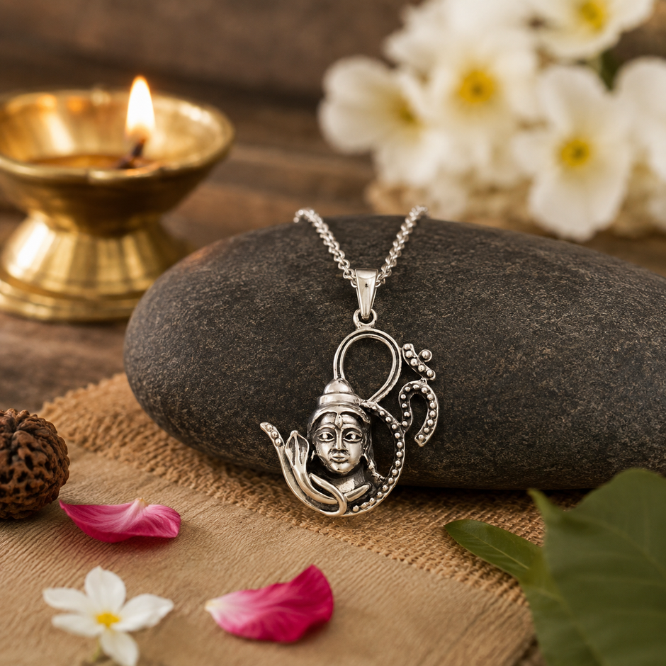 Shiv Ji OM Silver Finish Pendant on dark stone with diya, rudraksha and white flowers — spiritual setting