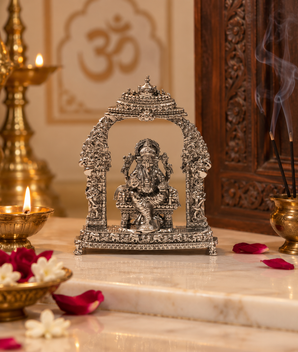 Silver finish Ganesh Ji idol with ornate temple arch displayed in a traditional home mandir with diya, incense and flowers – My Guru Ji