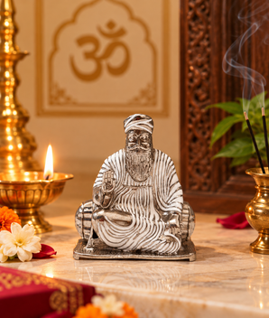 Silver finish Guru Nanak Dev Ji idol in blessing pose displayed in a traditional home temple with diya, incense and flowers – My Guru Ji.