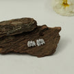 My Guru Ji Bhootnath stud earrings in silver finish featuring Hindi script and Shiva symbol on a rustic wood background