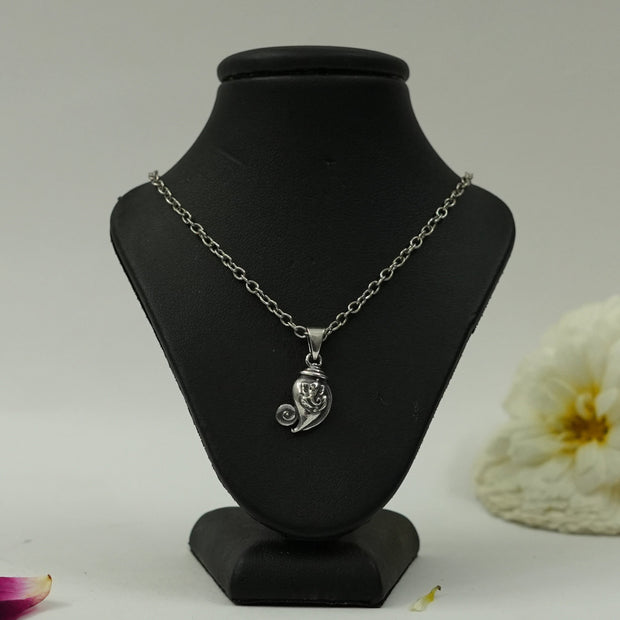 My Guru Ji silver plated brass Lord Ganesha pendant featuring an artistic Om swirl design on a black display stand.