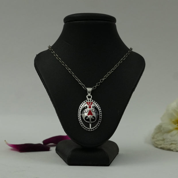 My Guru Ji Sacred Hanuman brass pendant with silver finish and red enamel detailing on a black display bust