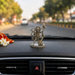 My Guru Ji silver finish brass Veer Hanuman Ji idol carrying Sanjeevani mountain, displayed on a car dashboard.