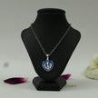 My Guru Ji silver finish brass Khanda shield pendant with blue enamel on a black display stand