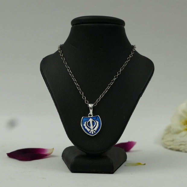 My Guru Ji silver finish brass Khanda shield pendant with blue enamel on a black display stand