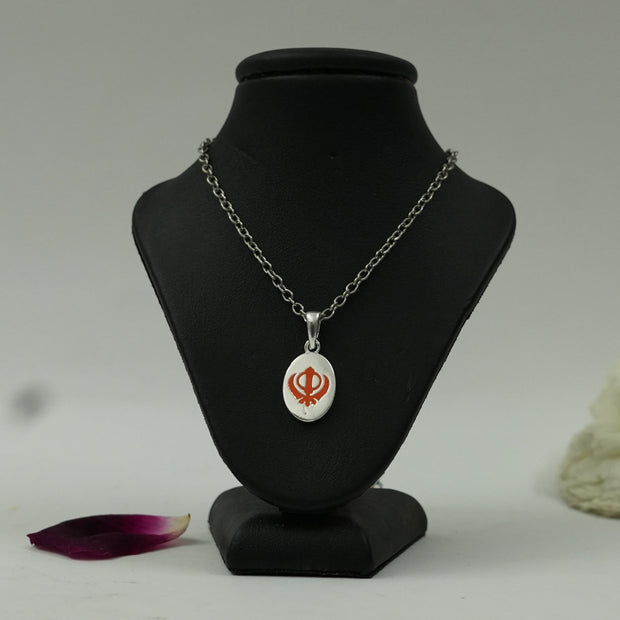 My Guru Ji silver finish brass pendant featuring a red enamel Khanda symbol displayed on a black mannequin bust