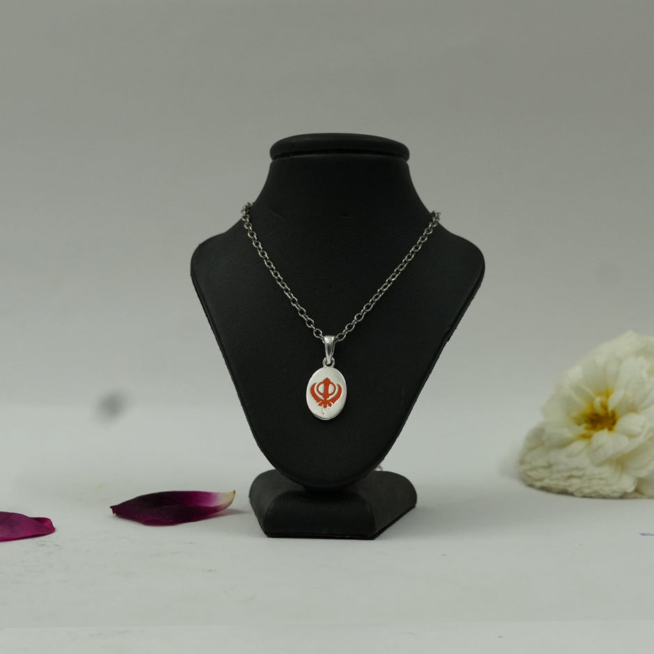 My Guru Ji silver finish brass pendant featuring a red Khanda symbol on an oval base displayed on a black bust