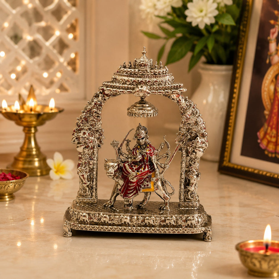 My Guru Ji Maa Durga idol in silver finish brass, seated on a lion under an ornate temple arch with a hanging bell.