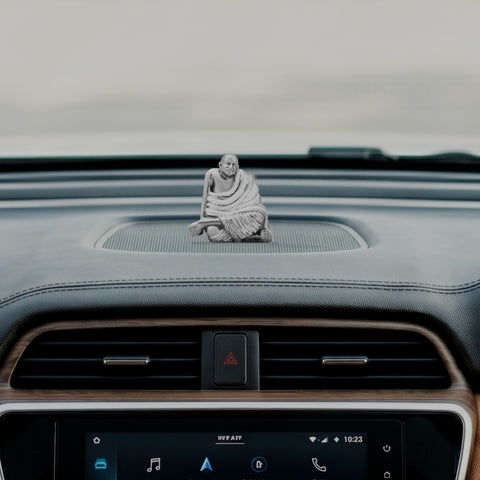 My Guru Ji Neem Karoli Baba brass idol placed on a car dashboard for spiritual protection and meditation