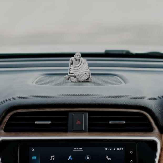 My Guru Ji Neem Karoli Baba brass idol placed on a car dashboard for spiritual protection and meditation
