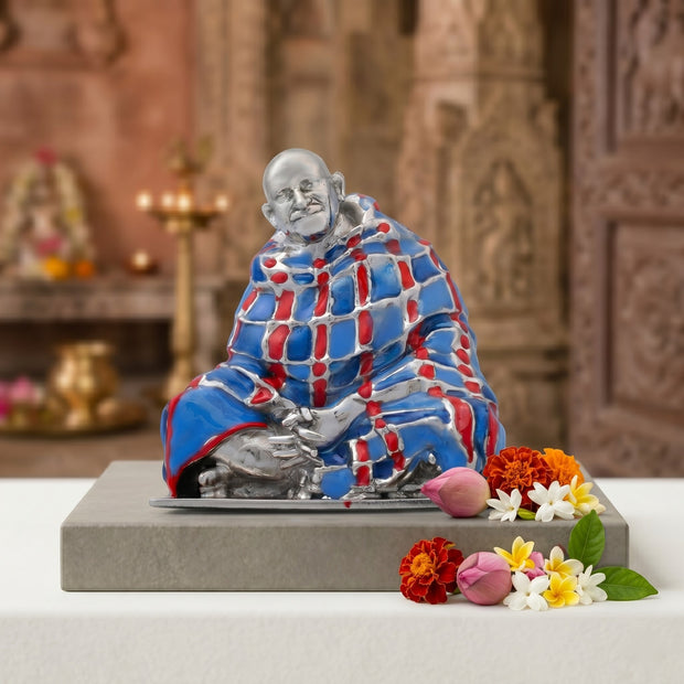 My Guru Ji Neem Karoli Baba brass idol with a hand-painted red and blue blanket, featuring a silver finish.