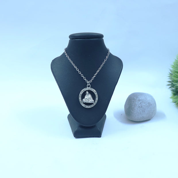 My Guru Ji silver-toned brass pendant featuring Neem Karoli Baba in blanket pose with Ram Ram engraving on a display.