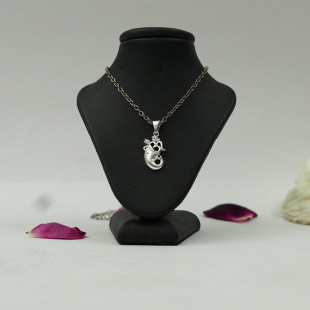My Guru Ji silver finish Om and Ganesh Ji spiritual pendant on a black display stand with rose petals