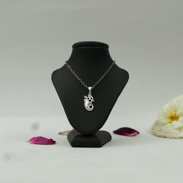 My Guru Ji silver finish Om and Ganesh Ji spiritual pendant on a black display stand with flower petals