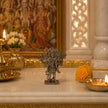 My Guru Ji silver-finish brass Panchmukhi Hanuman idol standing on a marble altar with traditional oil lamps and flowers