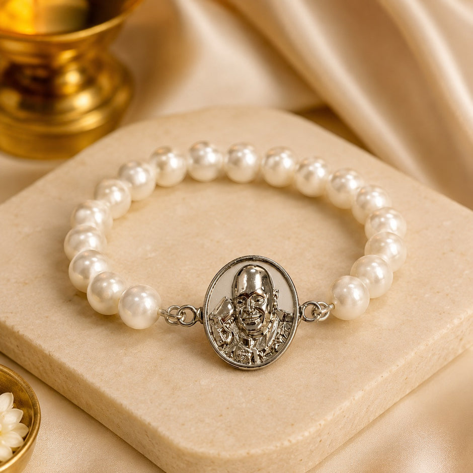 My Guru Ji stretchable pearl bracelet featuring a silver-finish brass Guru Ji charm on a beige stone surface.