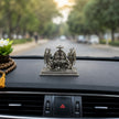 My Guru Ji silver finish brass Ram Darbar idol placed on a car dashboard with a mala and flower nearby.