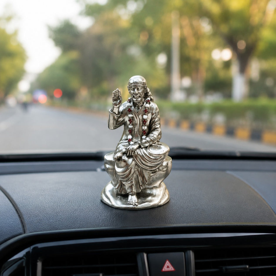 My Guru Ji silver-finished brass Shirdi Sai Baba idol seated on a car dashboard for spiritual protection and peace.