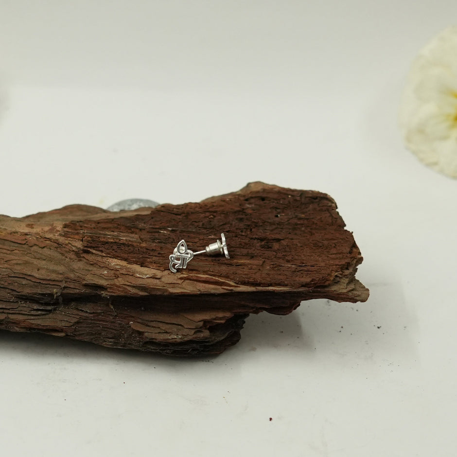 My Guru Ji silver finish brass stud earrings featuring the sacred Shree script design displayed on rustic wood.