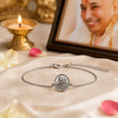 My Guru Ji silver-finish brass bracelet featuring a Guru Ji portrait charm and adjustable chain on a silk cloth.