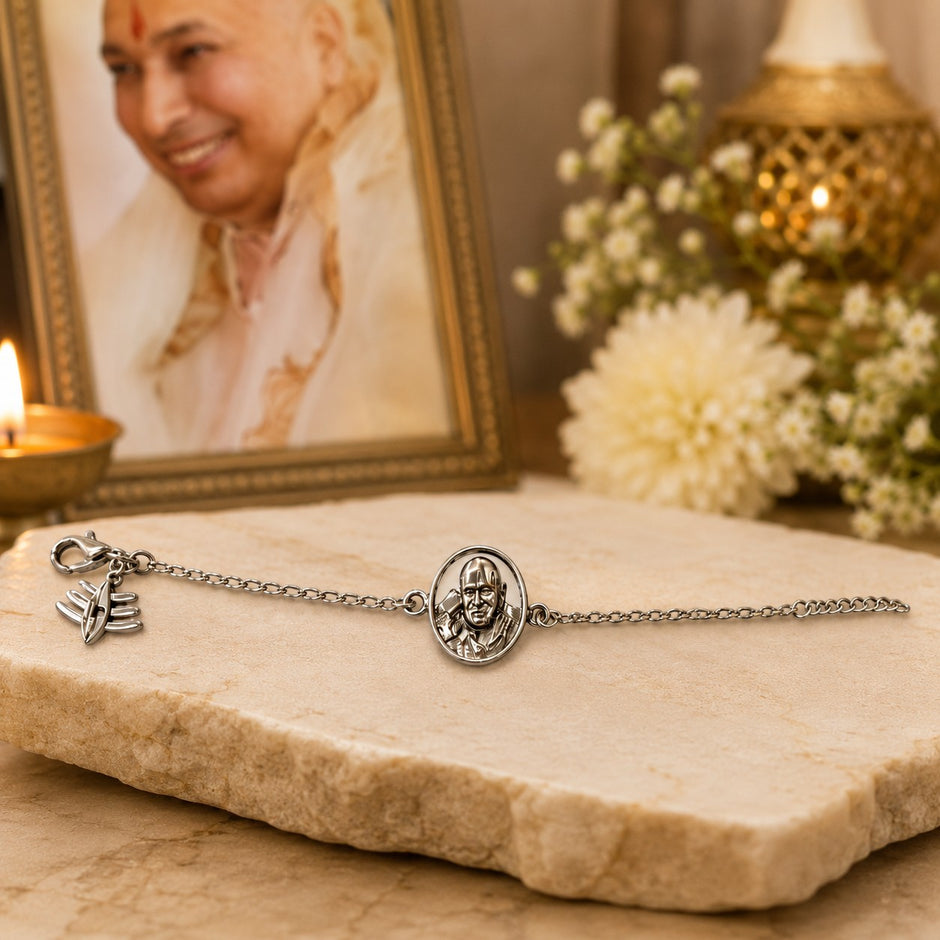 My Guru Ji silver-plated brass bracelet featuring a sacred portrait charm, displayed on a stone surface.