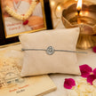 My Guru Ji silver finish brass bracelet featuring a sacred Guru Ji charm on a beige display cushion