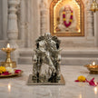 My Guru Ji silver finish brass idol of Guru Ji Bade Mandir Wale, displayed on a marble surface with diya lamps.