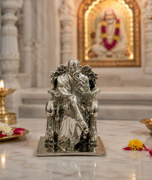 My Guru Ji silver finish brass idol of Guru Ji Bade Mandir Wale, displayed on a marble surface with diya lamps.