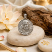 My Guru Ji round brass pendant with a silver finish, featuring an embossed portrait of Guru Ji on a stone surface.
