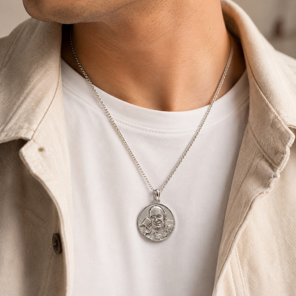 My Guru Ji round brass pendant with silver finish featuring an embossed portrait, worn by a man in a white shirt.