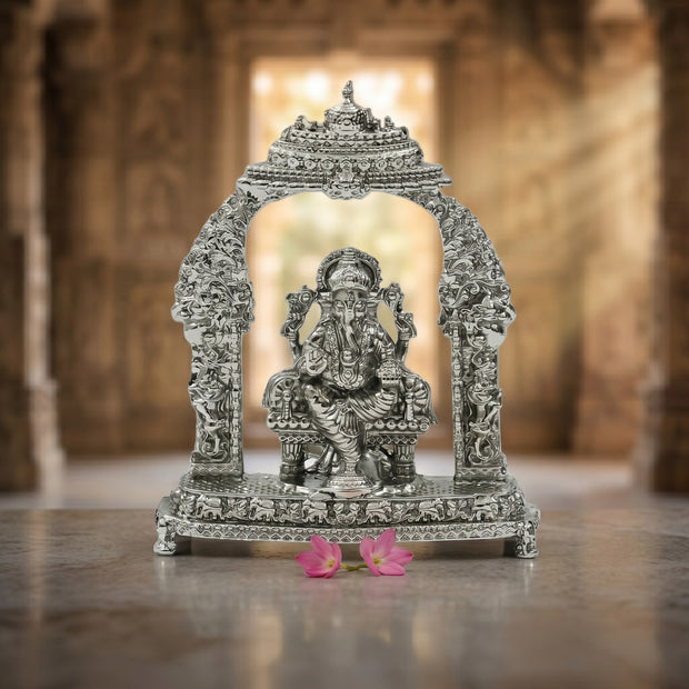 My Guru Ji silver-tone Lord Ganesha idol seated under an ornate arch with intricate carvings for pooja and home decor.