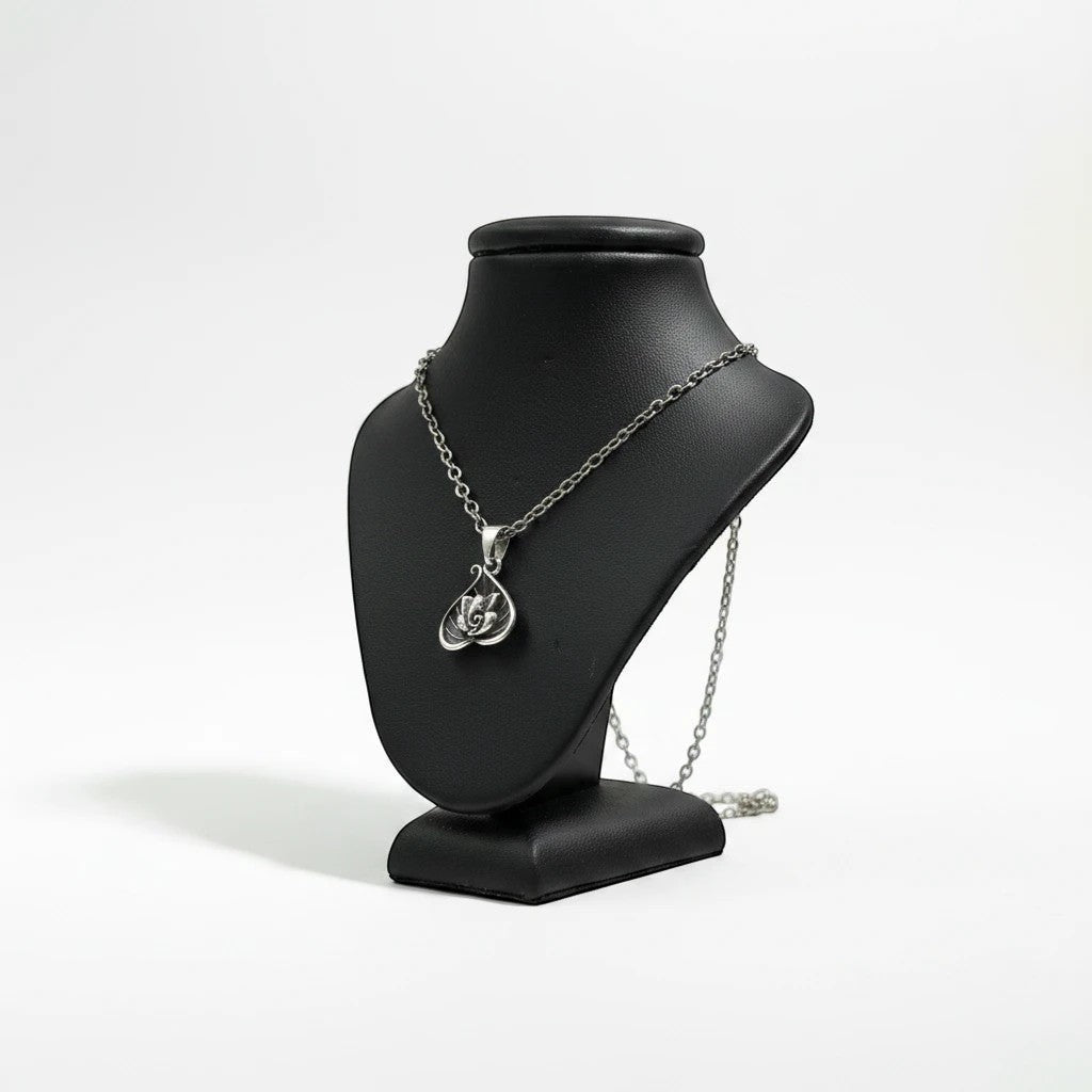 My Guru Ji silver plated brass Lord Ganesha pendant in a decorative leaf-shaped frame on a black display bust