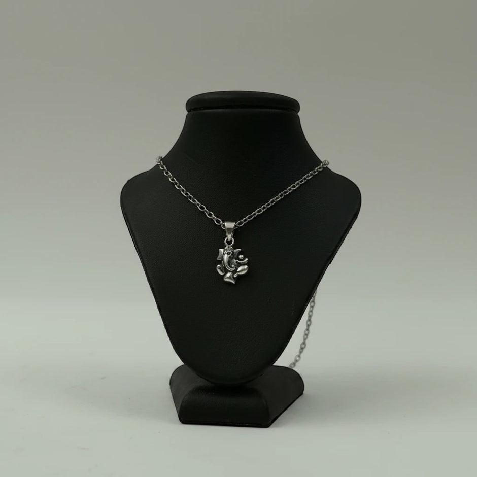 My Guru Ji silver plated brass Lord Ganesha pendant on a black display stand, featuring detailed devotional design.
