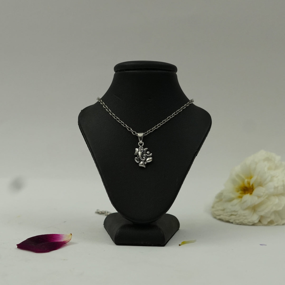 My Guru Ji silver plated brass Lord Ganesha pendant on a black display stand, featuring fine devotional detailing.