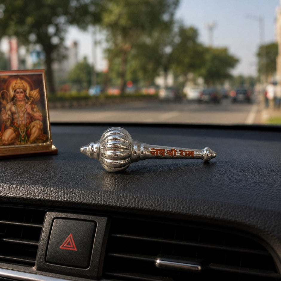 My Guru Ji silver finish brass Hanuman Gada with Jai Shri Ram engraving placed on a car dashboard