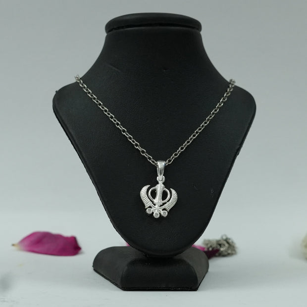 My Guru Ji silver plated brass Khanda pendant featuring an intricate spiritual symbol on a black display stand.