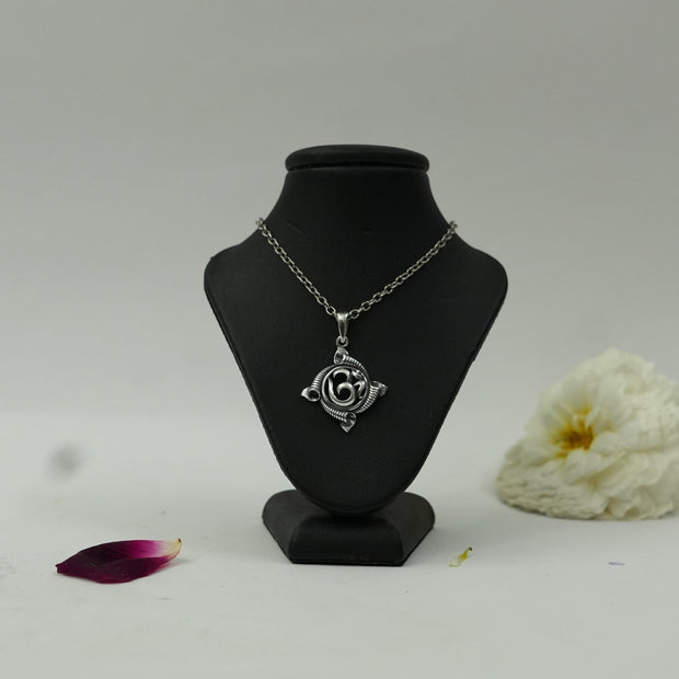 My Guru Ji silver plated brass Om pendant featuring a traditional circular spiritual motif on a black display bust.