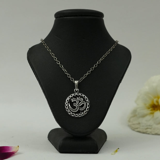 My Guru Ji silver plated brass round pendant featuring an intricate Om symbol on a black display stand