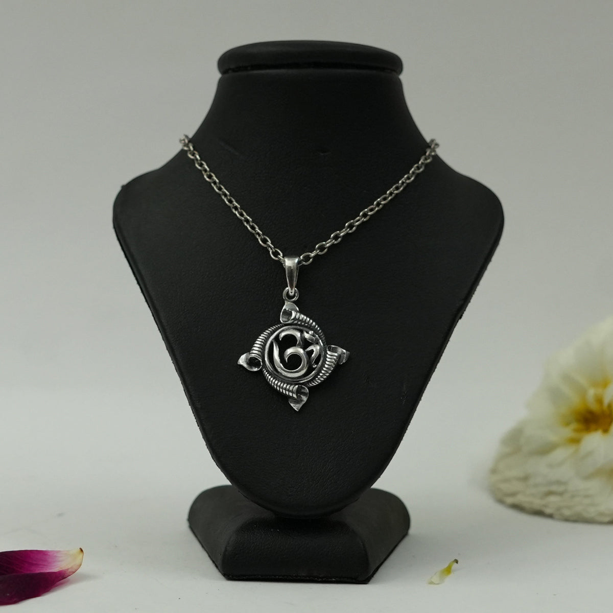 My Guru Ji silver plated brass Om pendant featuring a traditional circular spiritual symbol on a black display bust.