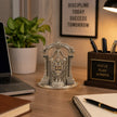 My Guru Ji silver finish brass Tirupati Balaji idol with temple arch displayed on an office desk with stationery.