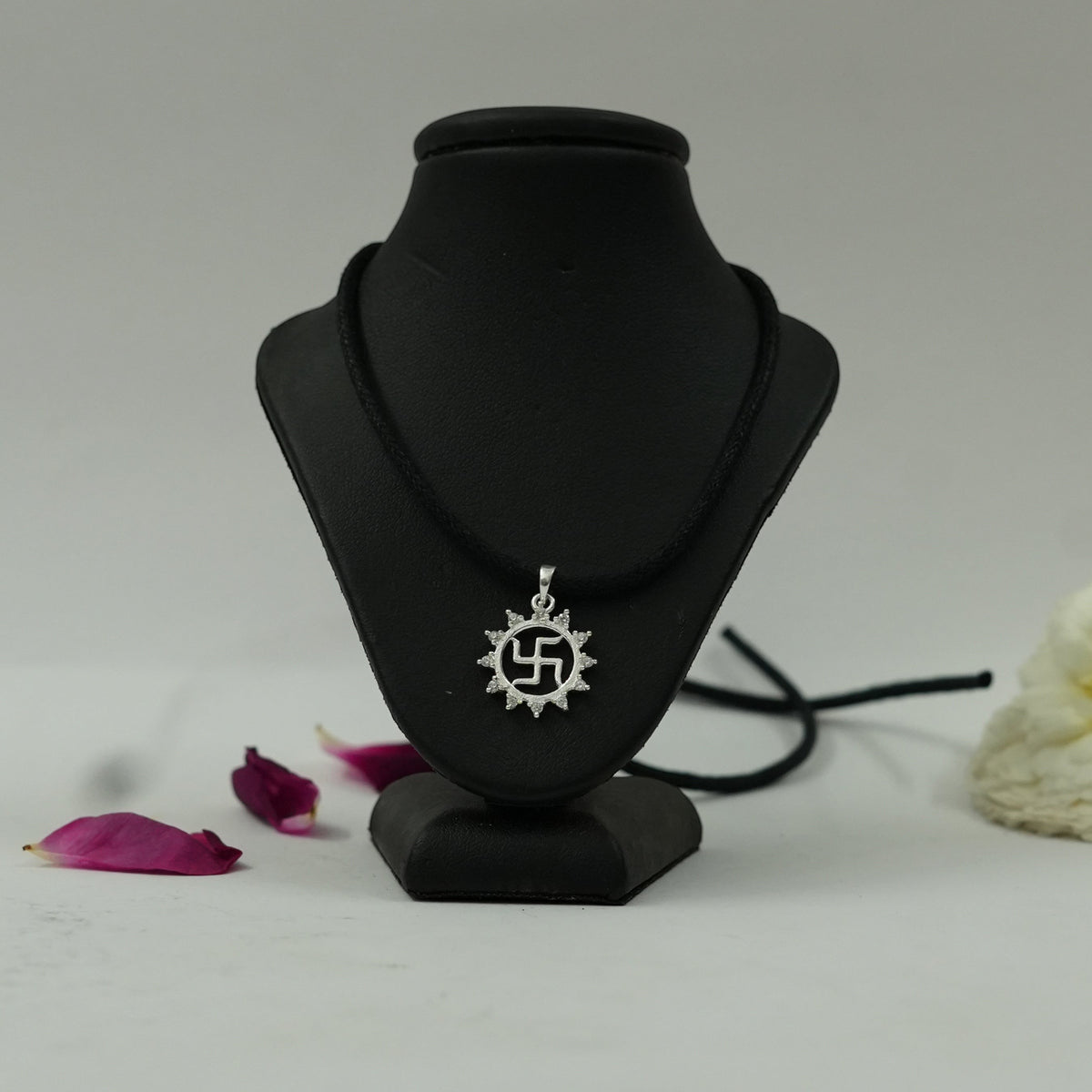 My Guru Ji silver-finish brass Swastik pendant with a vector chakra design on a black display stand