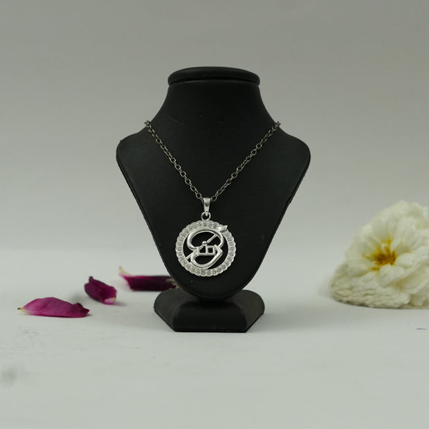 My Guru Ji silver-finish Tamil OM pendant featuring a circular frame with crystal accents on a black display bust.