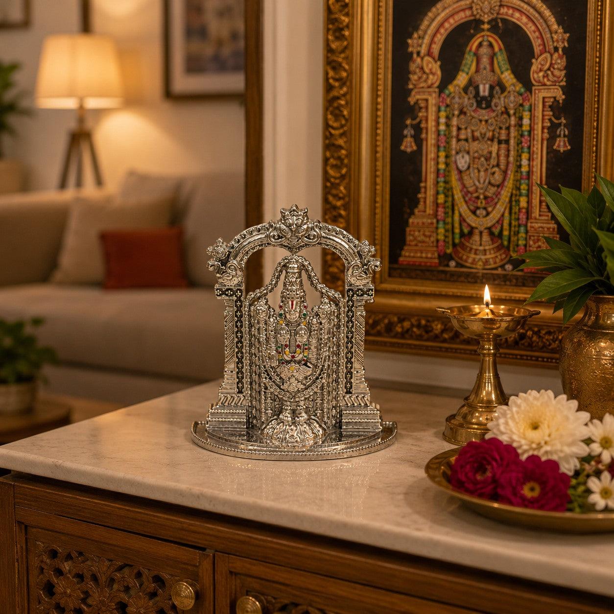 My Guru Ji silver finish brass Tirupati Balaji idol with temple arch displayed on a marble table with a lit diya.