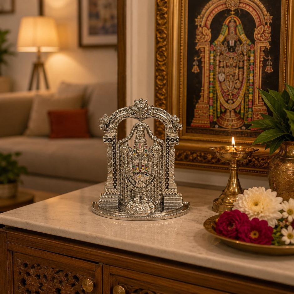 My Guru Ji silver finish brass Tirupati Balaji idol with temple arch displayed on a marble table with a lit diya.
