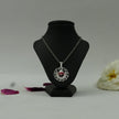 My Guru Ji Tirupati Balaji spiritual pendant with a silver finish and red devotional detailing on a display stand.