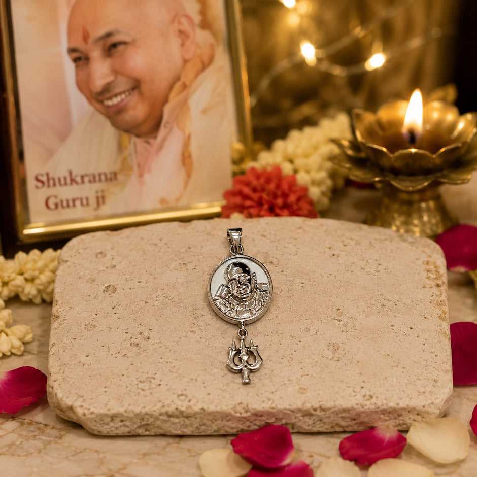 My Guru Ji silver-finish brass pendant featuring a sacred Guru Ji portrait and Trishul charm on a stone surface.
